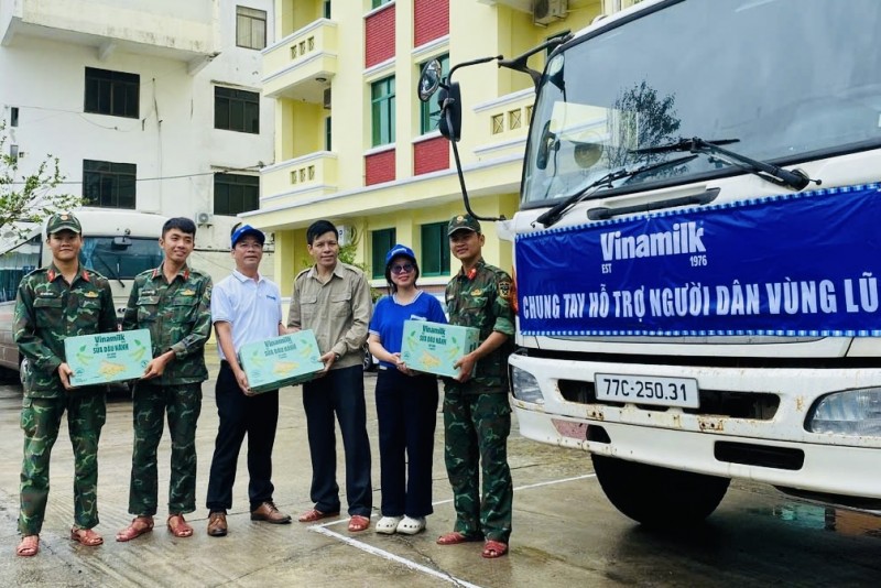 Hình 9a hoặc 9b (báo chọn 1 trong 2 hình): Anh Nguyễn Xuân Bình – Giám đốc Nhà máy Sữa Vinamilk Bình Định cùng cán bộ công nhân viên công ty trao tặng sản  phẩm dinh dưỡng Vinamilk - Ảnh: Vi Nam