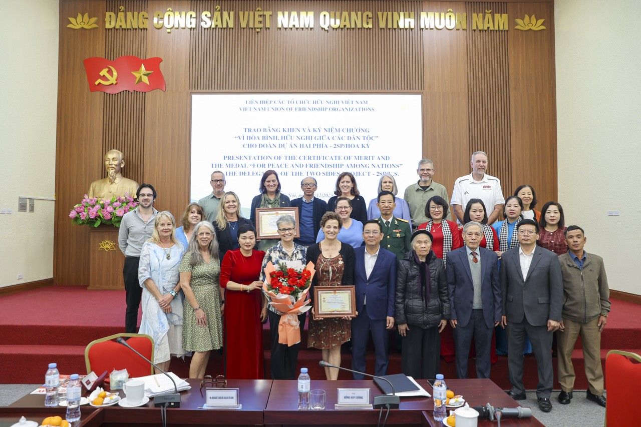 Vice President of the Vietnam Union of Friendship Organizations (VUFO) Đồng Huy Cương (front row, fifth from right) presents the Medal “For Peace and Friendship Among Nations” to Margaret Caroline Carlson Delogne, Founder and Executive Director of 2SP, along with a Certificate of Merit from VUFO awarded to the organization. (Photo: Đinh Hòa)