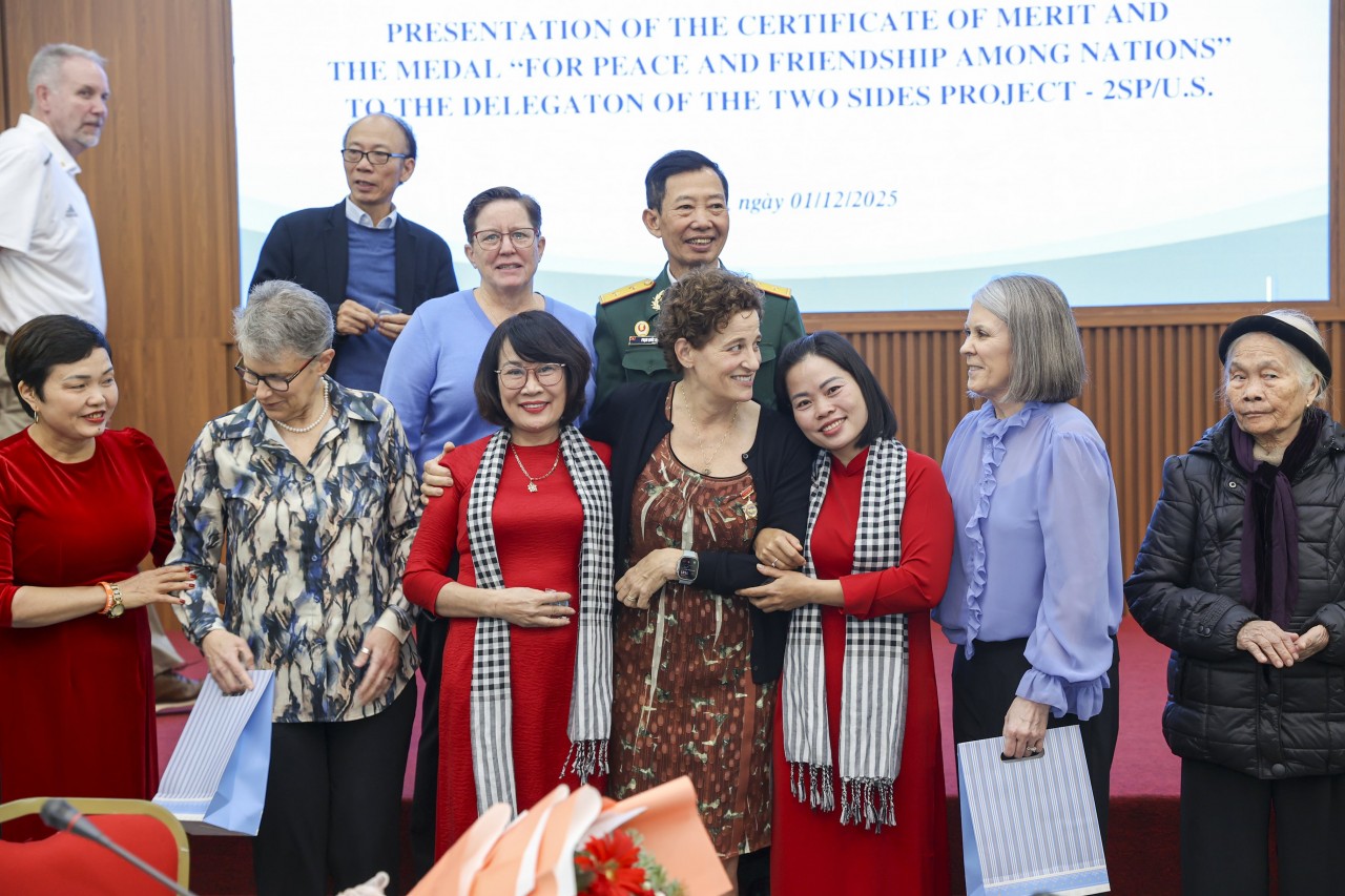 Vietnamese and American delegates exchange gifts and take commemorative photos. (Photo: Đinh Hòa)