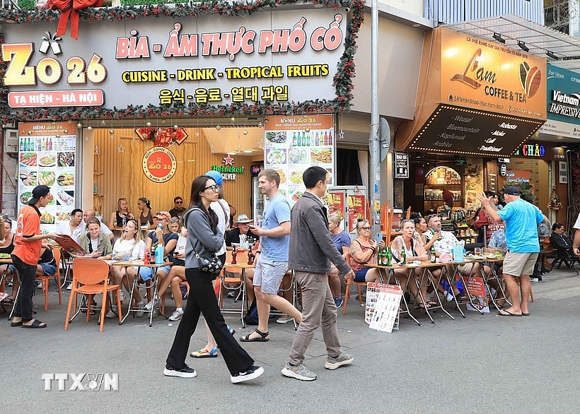 Foreign tourists savour local foods on Ta Hien street in Hanoi. (Photo: VNA) Foreign tourists savour local foods on Ta Hien street in Hanoi. (Photo: VNA)