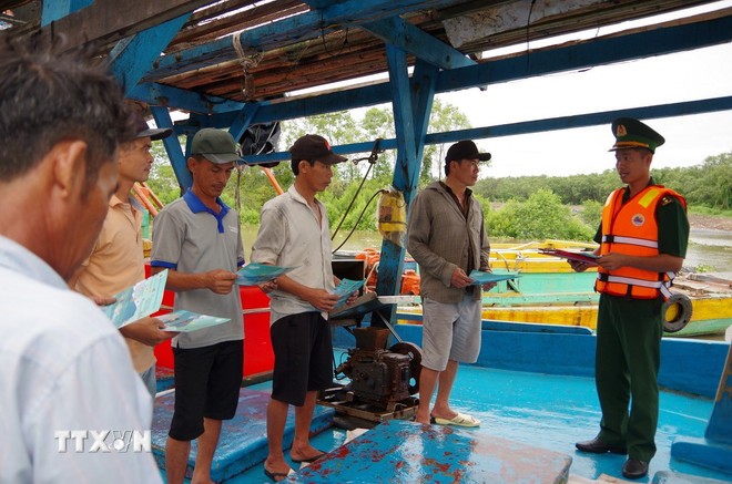 The Vam Lang Border Guard control station disseminates information on IUU fishing prevention and presents national flags to captains and fishermen. (Photo: Cong Tri/VNA).