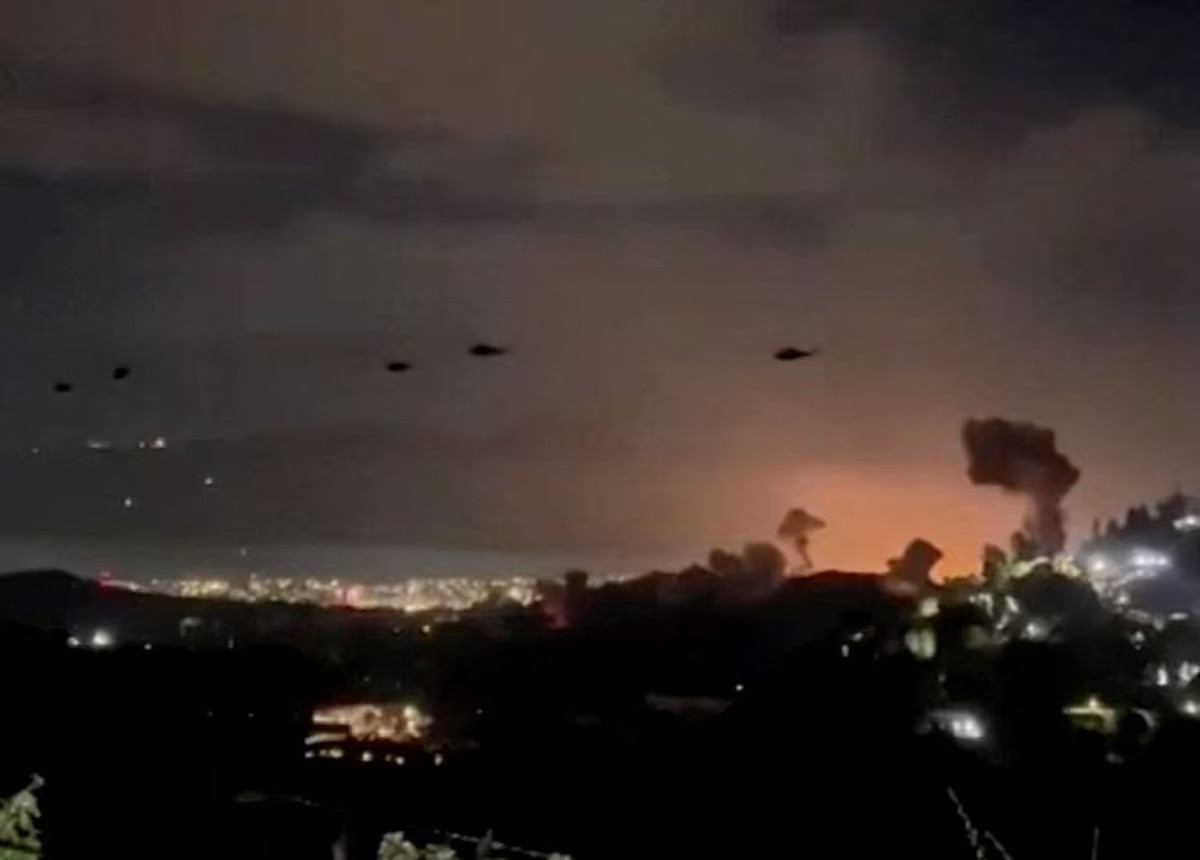 Hình ảnh cắt từ video do Reuters thu được cho thấy một trực thăng bay qua các cột khói bốc lên sau những vụ nổ tại Caracas, Venezuela, ngày 3/1/2026. Ảnh: Reuters/REUTERS.