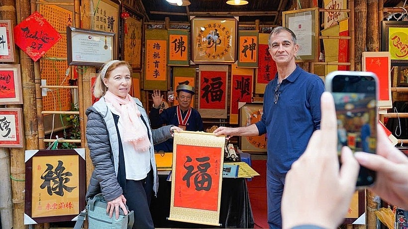 International visitors experience the traditional new year calligraphy activity (Photo: VNA) International visitors experience the traditional new year calligraphy activity (Photo: VNA)