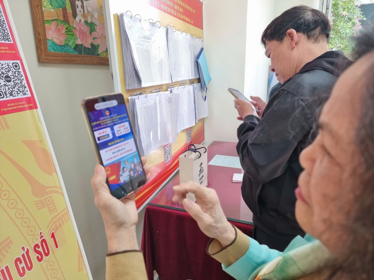 Residents scan QR codes to access updated information about election work. (Photo: baotintuc.vn)