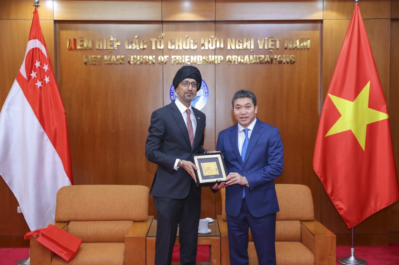 Ambassador Extraordinary and Plenipotentiary of the Republic of Singapore to Vietnam Rajpal Singh (left) presents a souvenir to the Vietnam Union of Friendship Organizations. (Photo: Đinh Hòa)