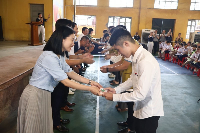 A representative of the Hai Phong Union of Friendship Organizations presents scholarships to disadvantaged students. (Photo: Nguyen Hanh/haiphong.gov.vn)