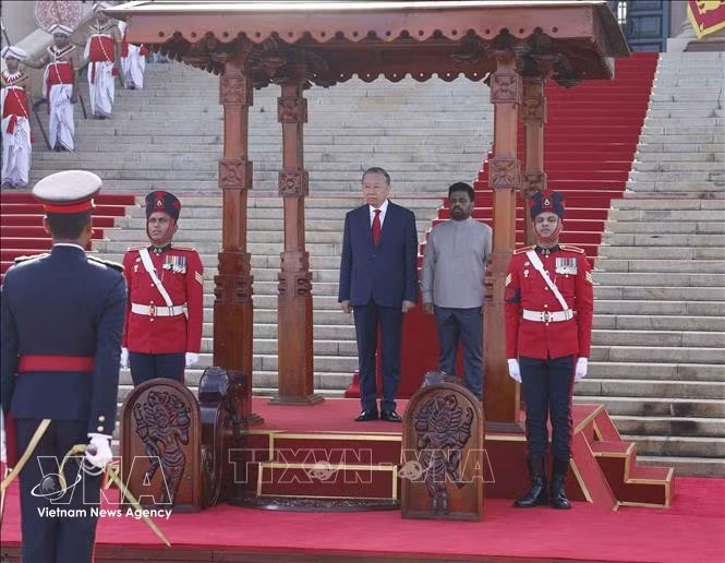 The Vietnamese and Sri Lankan leaders stand on the ceremonial platform. (Photo: VNA)