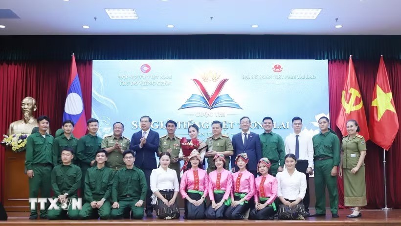 Đại sứ Việt Nam tại Lào Nguyễn Minh Tâm và Thứ trưởng Bộ Giáo dục và thể thao Lào Kingmono Phommahaxay trao giải cho đội đạt giải Nhất cuộc thi. (Ảnh: TTXVN)