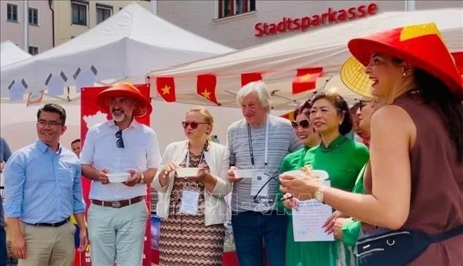 Head of the Integration and Social Affairs Department of Augsburg Martin Schenkelberg (wearing conical hat) visited Vietnamese pavilion (Photo: Nhan Dan)