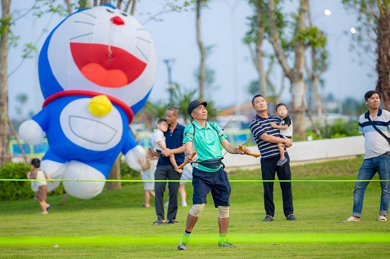 Nghệ nhân Phạm Văn Tâm giao lưu và hướng dẫn các gia đình nghệ thuật thả diều tại công viên Central Forest rộng 5ha