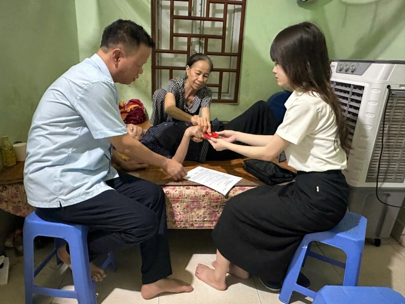 Cán bộ BHXH Hà Nội hỗ trợ người dân cao tuổi thủ tục uỷ quyền (Ảnh: T.L)