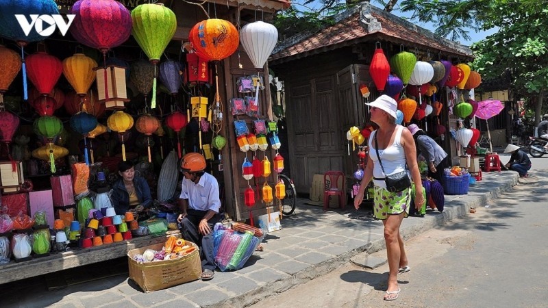 A tourist strolls along lantern-lit streets in Hoi An Ancient Town.