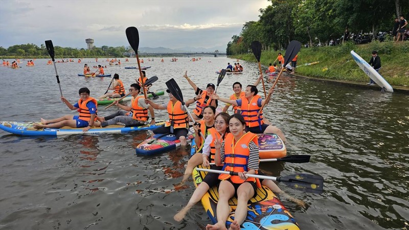 People do stand-up paddleboarding on Huong river. (Photo: Lao Dong Newspaper)