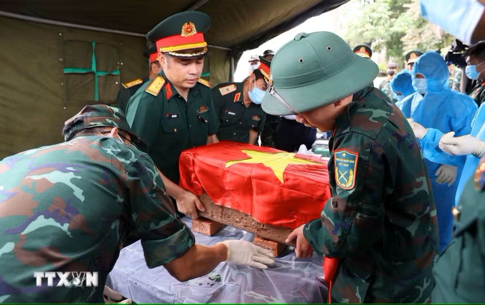 Authorities solemnly carry out the excavation process and transfer the unidentified remains of fallen soldiers to the area for collecting biological samples at Ngoc Hoi Martyrs' Cemetery in Thanh Tri Commune. (Photo: Van Diep/VNA)