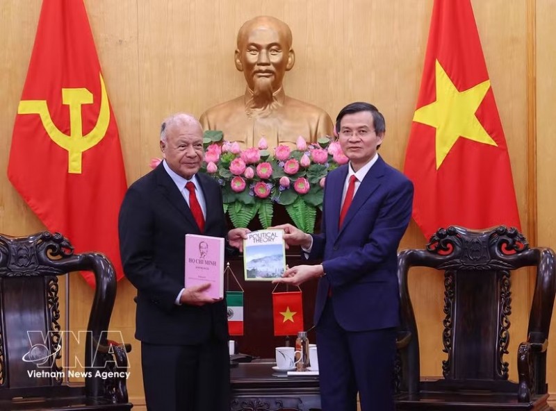 President of the Ho Chi Minh National Academy of Politics Assoc. Prof. Dr. Doan Minh Huan (R) presents books to PT General Secretary Alberto Anaya Gutiérrez at their meeting in Hanoi on August 19. (Photo: VNA)
