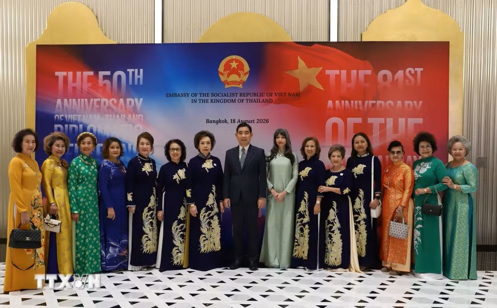 Ambassador Pham Viet Hung and his wife Ho Thi Thu Trang pose for a commemorative photo with Vietnamese women living in Thailand. (Photo: Do Sinh/VNA)