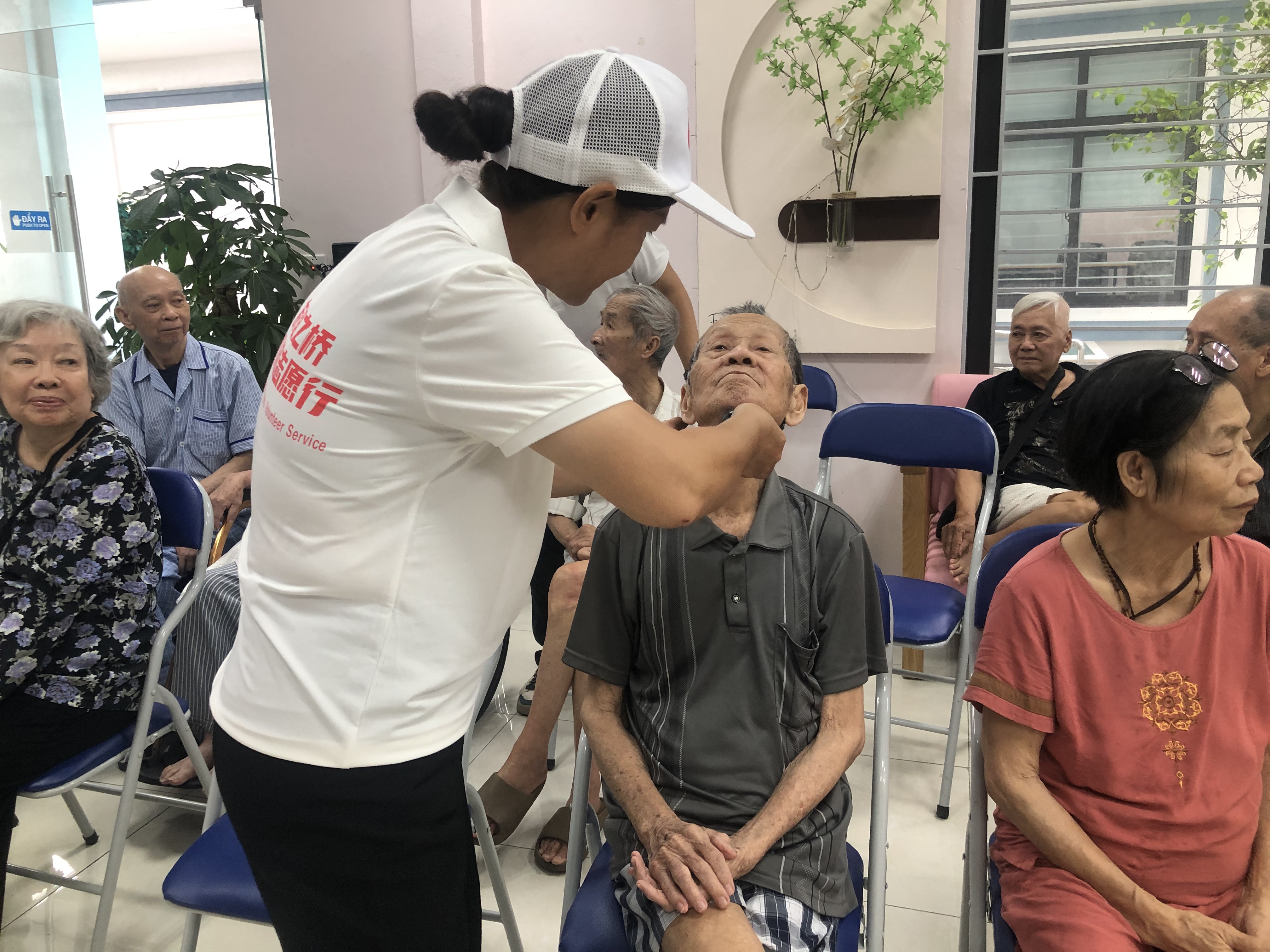 志愿者认真的为老人剃胡子 志愿者认真的为老人剃胡子