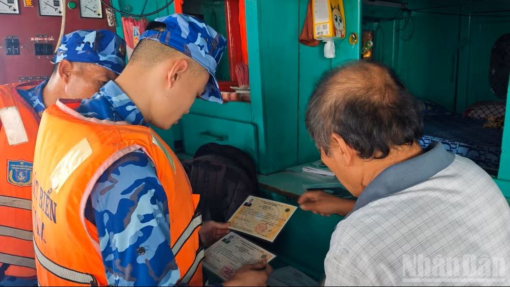A patrol and inspection team checks the documents of a fishing vessel operating at sea. (Photo: Van Thuong/People's Newspaper)