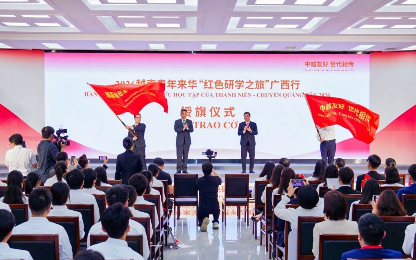Leaders of the Viet Nam Union of Friendship Organizations and the Chinese People’s Association for Friendship with Foreign Countries present flags to representatives of the two countries’ youth participating in the “Viet Nam–China Border People’s Festival and Red Journey for Youth Research and Study 2026” in Guangxi, China, in April 2026. (Photo: Chinese People’s Association for Friendship with Foreign Countries)