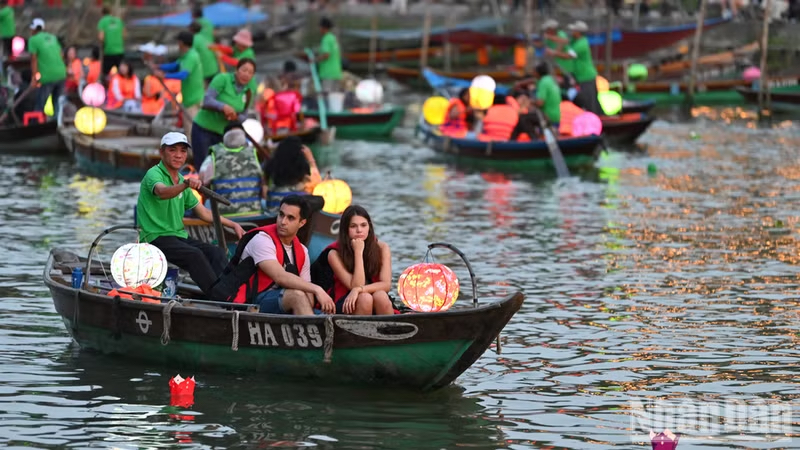 International tourists release flower lanterns on the Hoai River in Hoi An. (Photo: THE DAI)