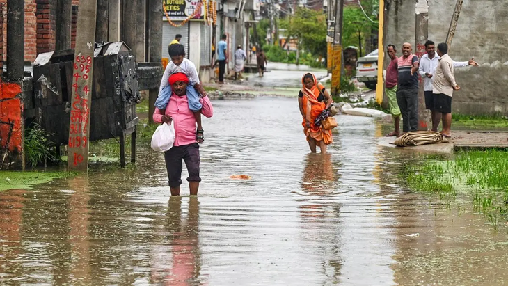 Người dân lội qua khu vực ngập nước sau những trận mưa lớn kéo dài ở Faizullaganj, thành phố Lucknow, Ấn Độ ngày 26-9 - Ảnh: ANI Người dân lội qua khu vực ngập nước sau những trận mưa lớn kéo dài ở Faizullaganj, thành phố Lucknow, Ấn Độ ngày 26-9 - Ảnh: ANI