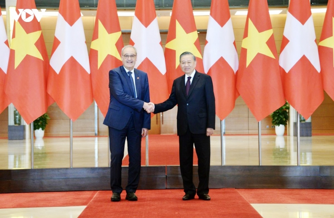 General Secretary of the Communist Party of Vietnam Central Committee and State President To Lam (R) and Swiss President Guy Parmelin shak hands ahead ò their talks in Hanoi on October 17, 2026 .