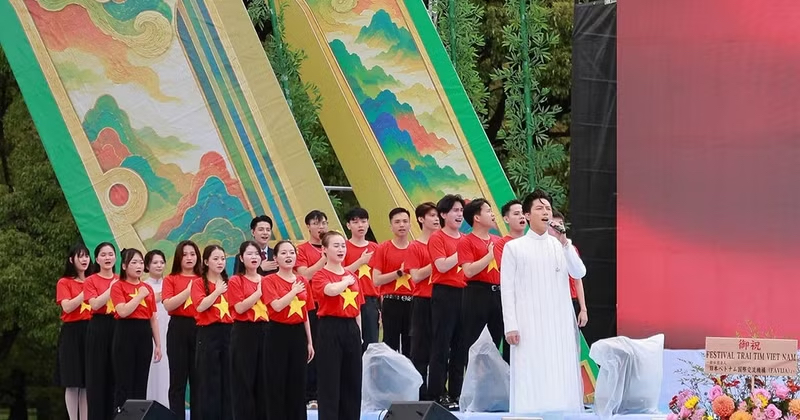 Singer Anh Tu joins 34 overseas Vietnamese in singing the Vietnamese National Anthem. (Photo: Organizing Committee)