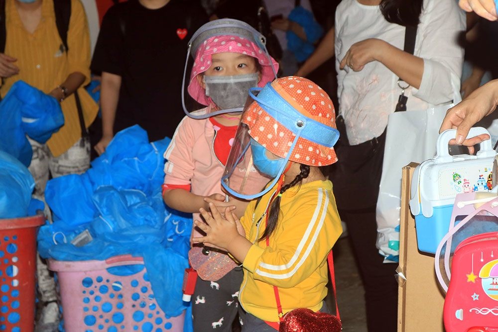 Hai em bé theo cha mẹ từ Singapore về nước đeo khẩu trang, nón chống giọt bắn kỹ lưỡng, được người lớn nhắc nhở rửa tay bằng dung dịch sát khuẩn nhiều lần trong ngày. hai em be theo cha me tu singapore ve nuoc deo khau trang non chong giot ban ky luong duoc nguoi lon nhac nho rua tay bang dung dich sat khuan nhieu lan trong ngay