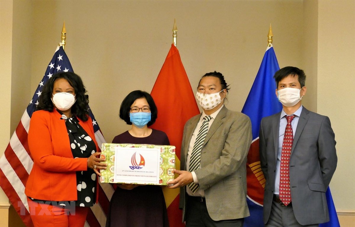 Tham tán Công sứ Hoàng Thị Thanh Nga trao tặng khẩu trang cho đại diện chính quyền thủ đô Washington. (Ảnh: TTXVN) tham tan cong su hoang thi thanh nga trao tang khau trang cho dai dien chinh quyen thu do washington anh ttxvn