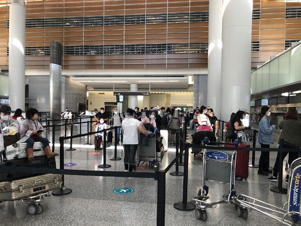 Các công dân Việt Nam làm thủ tục chuẩn bị lên máy bay (Ảnh: Tapchiquehuong) cac cong dan viet nam lam thu tuc chuan bi len may bay anh tapchiquehuong