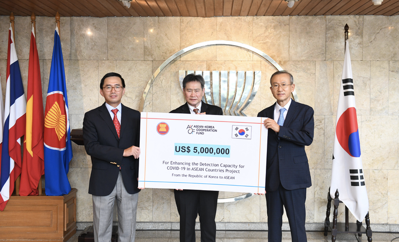 Đại sứ Trần Đức Bình (trái) và Tổng thư ký ASEAN, Dato Lim Jock Hoi (giữa) nhận bàn giao dự án hỗ trợ ứng phó Covid-19 từ Hàn Quốc. dai su tran duc binh trai va tong thu ky asean dato lim jock hoi giua nhan ban giao du an ho tro ung pho covid 19 tu han quoc