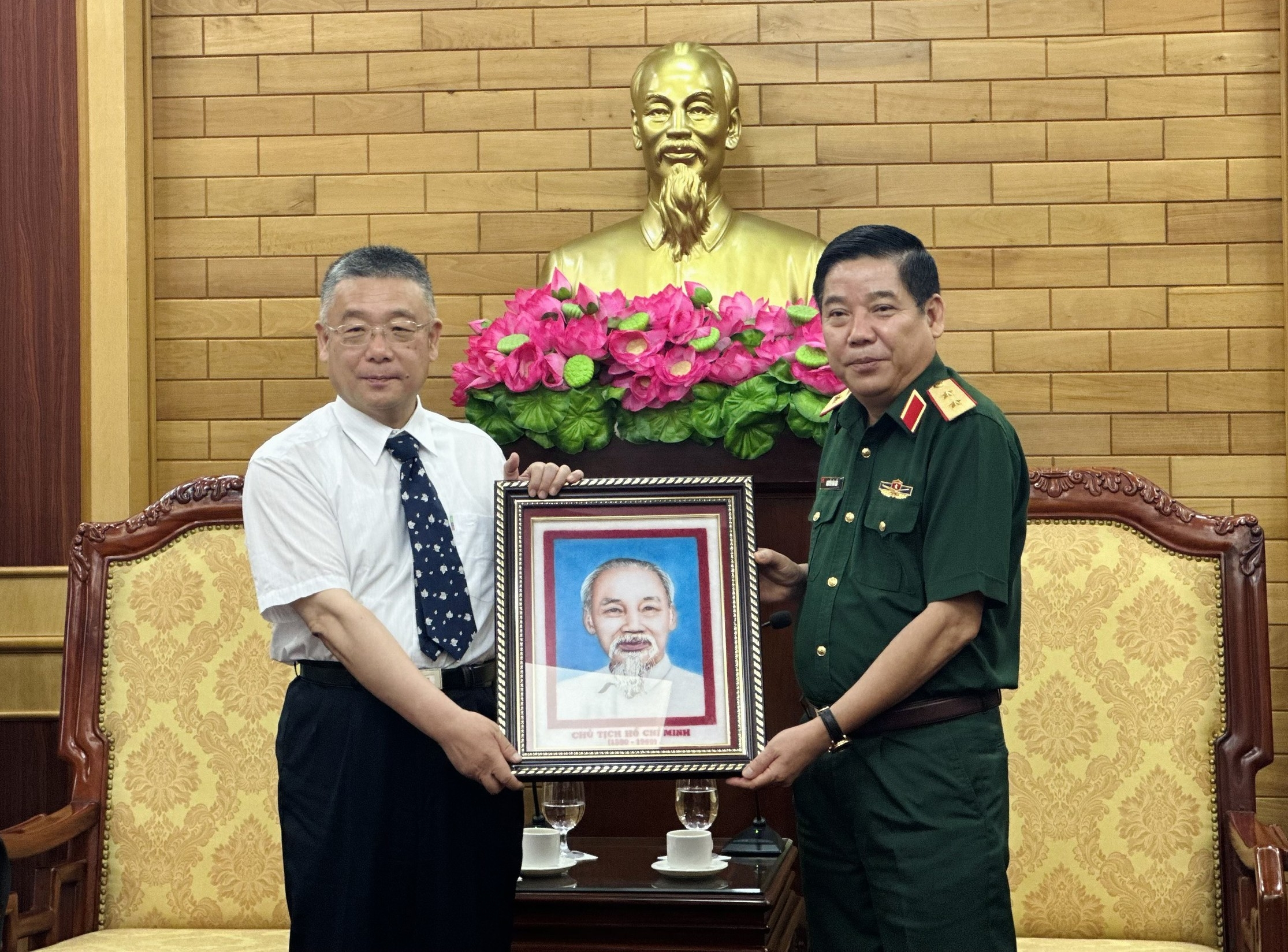 阮文熊中将(右)向韦肖毅赠送胡志明主席图片。 阮文熊中将(右)向韦肖毅赠送胡志明主席图片。