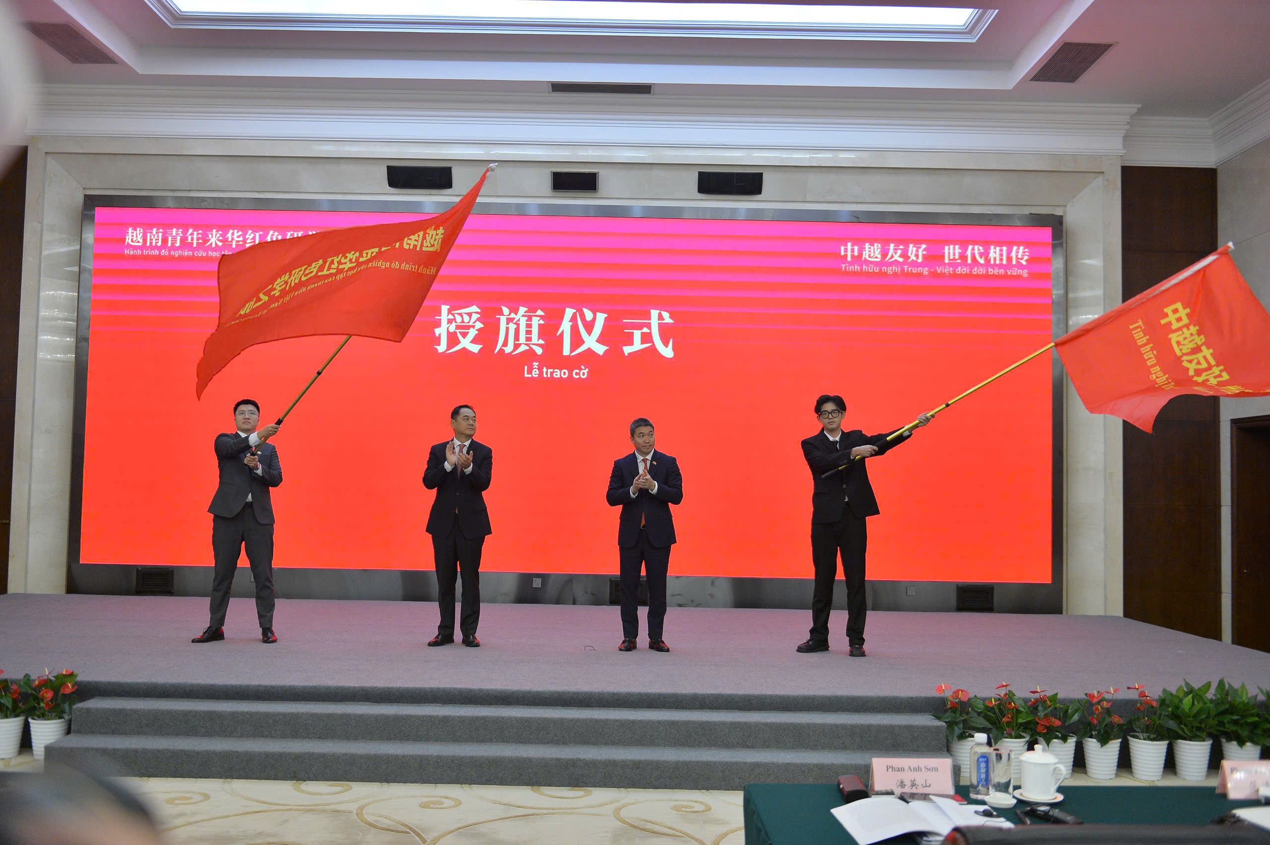 越南青年在中国重庆的红色之旅:以青春之力加深友谊纽带 Đc Dương Vạn Minh và Phan Anh sơn trao cờ cho đại diện thanh niên hai nước Việt Trung