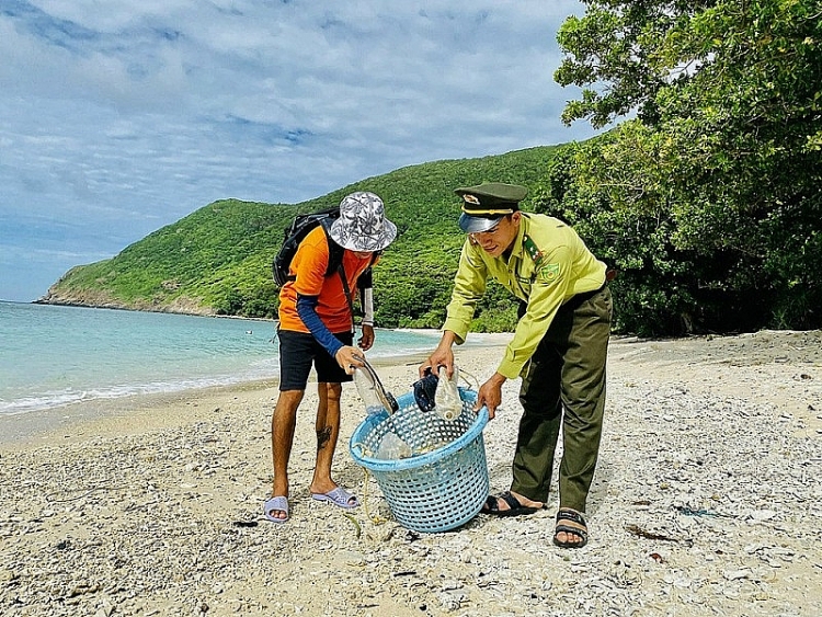 ນັກ​ທ່ອງ​ທ່ຽວ ​ແລະ ​ກຳລັງກວດກາ​ ເຂດ​ປ່າ​ສະ​ຫງວນ​ແຫ່ງ​ຊາດໂກນດາວ ( Con Dao) ຮ່ວມ​ກັນ​ເກັບ​ກຳ​ຂີ້​ເຫຍື້ອ​ຈາກ​ມະ​ຫາ​ສະ​ໝຸດ ໄຫຼ​ເຂົ້າມາໝູ່​ເກາະໄບແກງ (Bay Canh) (ພາບ: KT)