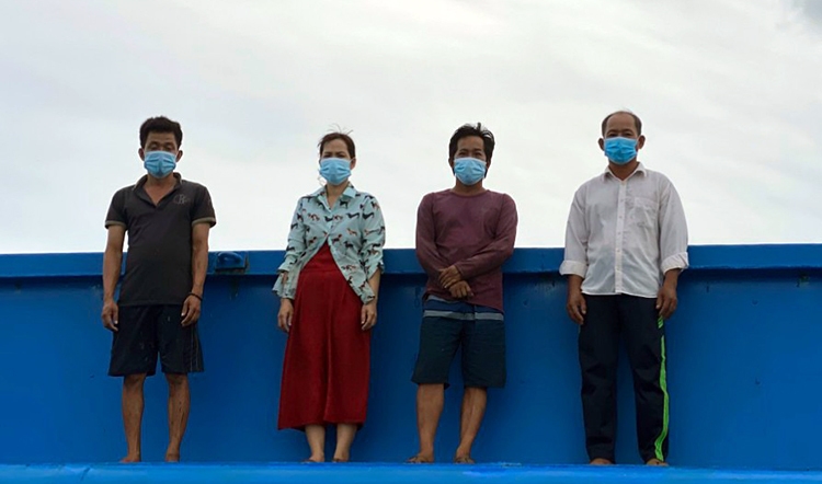Ông Tân (bìa phải) cùng 3 người khác trên sà lan khi bị lực lượng biên phòng phát hiện. Ảnh: Vinh Tiến Ông Tân (bìa phải) cùng 3 người khác trên sà lan khi bị lực lượng biên phòng phát hiện. Ảnh: Vinh Tiến
