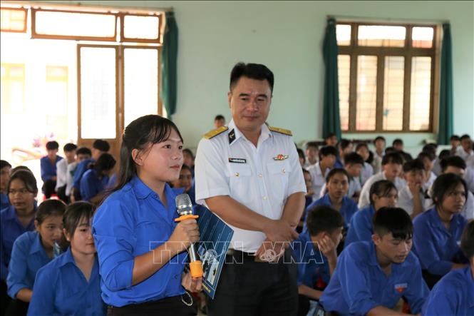 Báo cáo viên của Tổng công ty Tân cảng Sài Gòn và các em học sinh cùng tìm hiểu về lịch sử Quân chủng Hải quân. Ảnh: Ngọc Minh/TTXVN