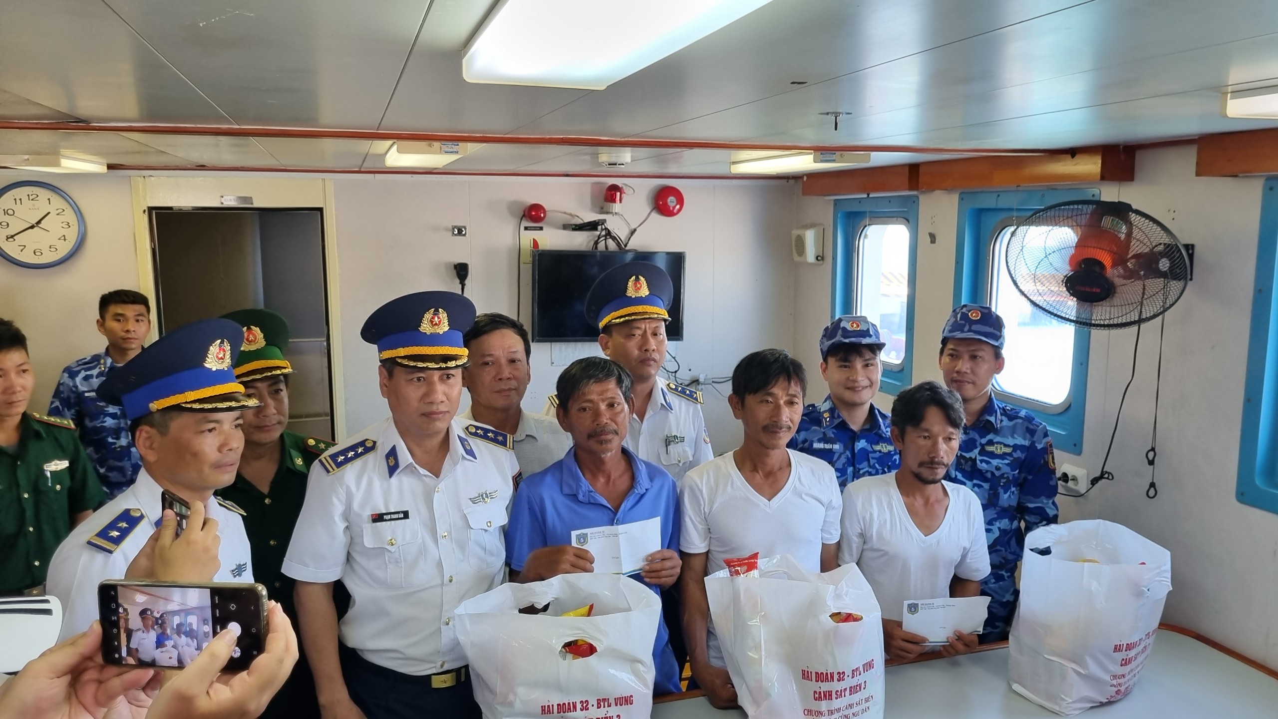 Lực lượng Cảnh sát biển và chính quyền địa phương tặng quà hỗ trợ các ngư dân may mắn thoát nạn. Ảnh: Trung Vũ.