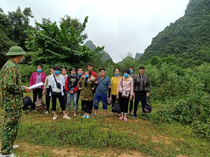 Cán bộ Đồn Biên phòng Ngọc Côn lấy lời khai của 13 công dân nhập cảnh trái phép. Ảnh: Báo Biên Phòng 2717 30230738pm anh 1
