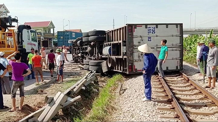 Video: Tránh xe máy đi ẩu, xe tải húc bay dải phân cách rồi nằm lăn trên đường sắt video tranh xe may di au xe tai huc bay dai phan cach roi nam lan tren duong sat