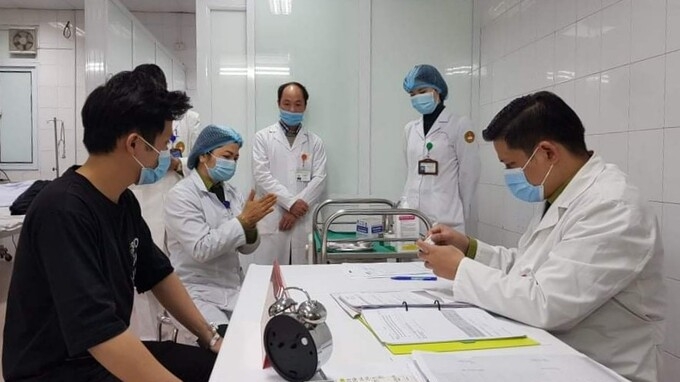 undefined One volunteer (in black shirt) getting the 25 mcg jab on January 14 (Photo: VNE)