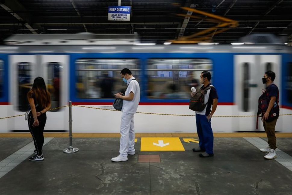 undefined Passengers wearing face masks for protection against the coronavirus disease (COVID-19) maintain social distancing while queueing to ride a train in Quezon City, Metro Manila, Philippines, July 21, 2020.