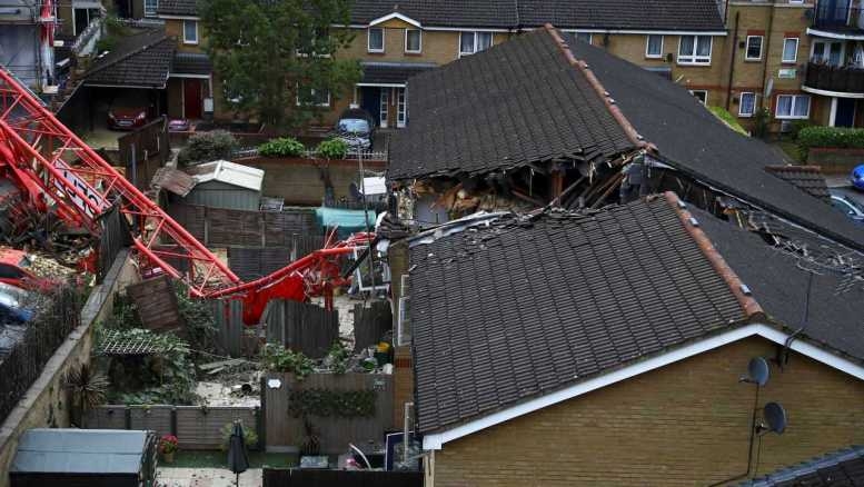 undefined A 20-metre long crane fell on two houses in east London on Wednesday afternoon, killing one woman and injuring four other people.