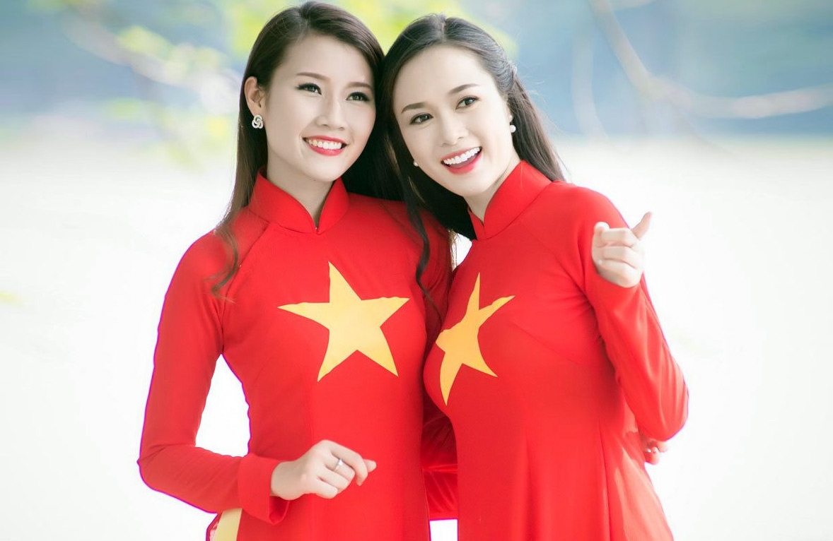 Vietnamese Women’s Day: History, Meaning, Activities Two women wearing Ao Dai in the colors and images of Vietnam's national flag (Photo: Redsvn)