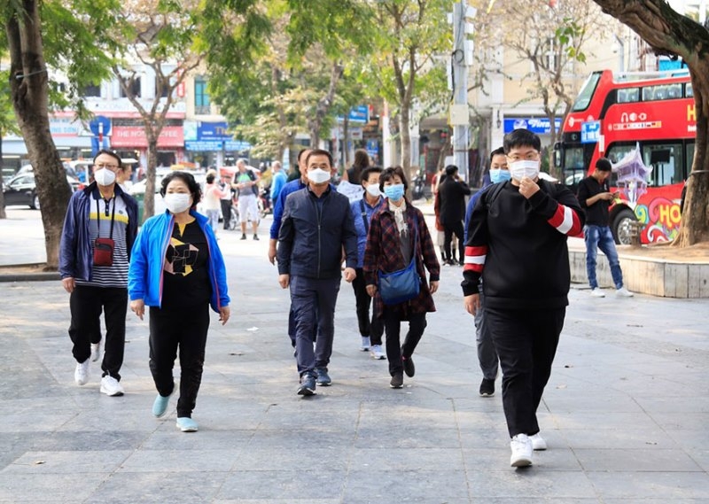 Hanoi, HCMC to halt unnecessary crowded activities over COVID-19 concerns People are all wearing face masks outside (photo: nhan dan)