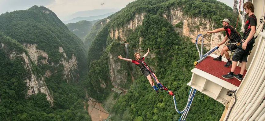 Thrilling bungee jumping from glass-bottom bridge in Central China A visitor takes a bungee jump from Zhangjiajie Glass Bridge (Photo: China highlights)