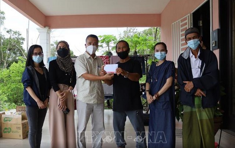 Tham tán Đại sứ quán Việt Nam tại Malaysia Nguyễn Hồng Sơn trao quà cho bà con người Chăm tại Charating, bang Pahang. (Ảnh: Mạnh Tuân/TTXVN)