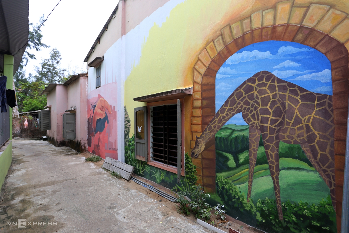 The wall of a narrow alley is covered with murals. The wall of a narrow alley is covered with murals.