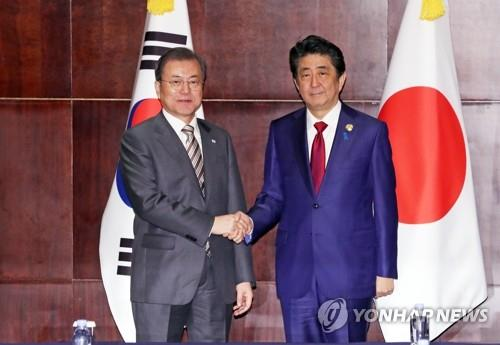 Tổng thống Hàn Quốc Moon Jae In (ảnh trái) bắt tay Thủ tướng Nhật Bản Abe Shinzo.. Nguồn: Yonhap. 4418 aen20200628002000325 01 i p4