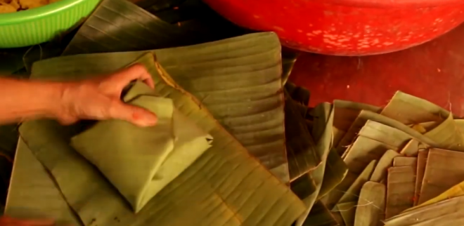 6. It is very important that the contents don't shift or spill during cooking. If the boiling water penetrates into the cake, it will make the cake soggy. So it is a great help to wrap it one more time. For the first layer, make sure the darker side of banana leaf faces the rice so that it can tint the cake with a nice subtle green color later. However, for last layer, the darker side of banana leaf should face outside to give it a beautiful green package. 2915 6