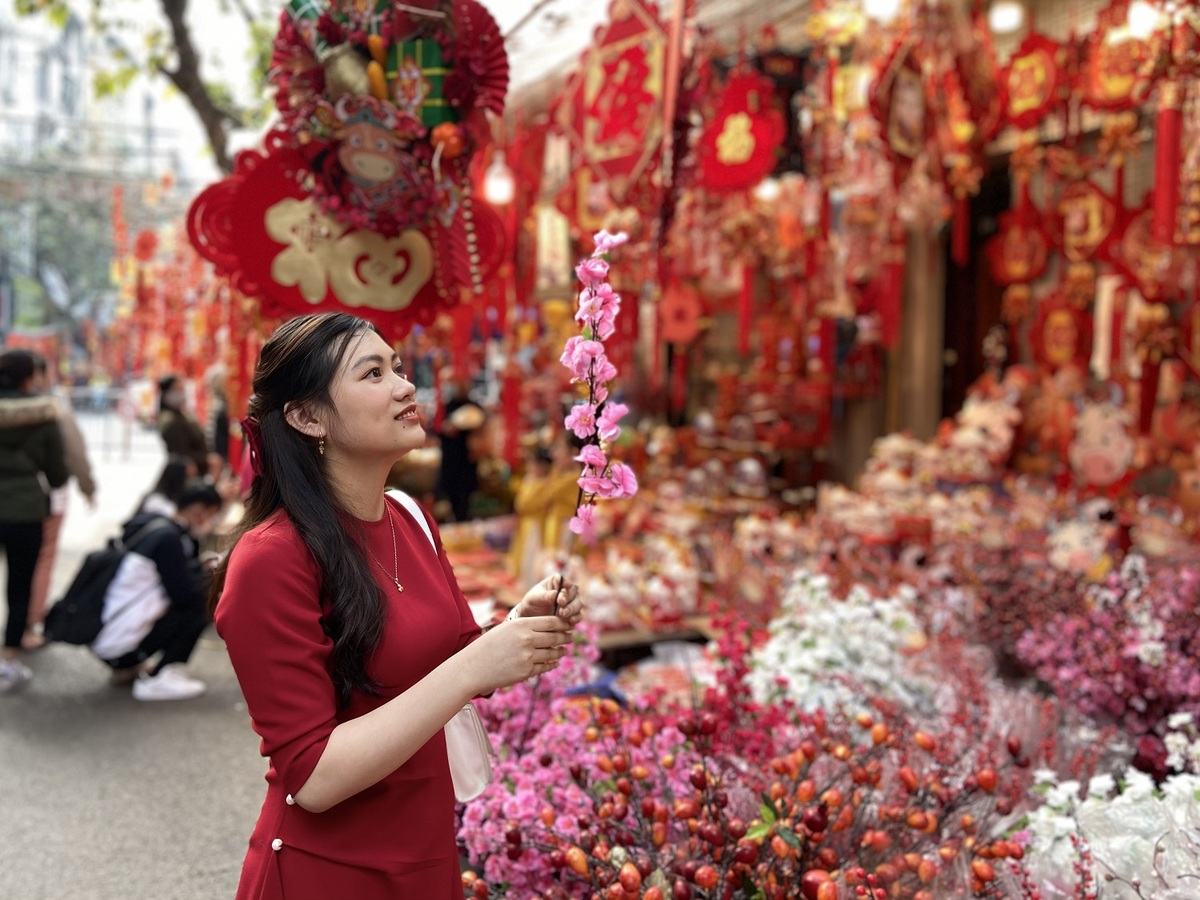 Huong Giang from Ha Nam Province said this is the first time she came to a Tet market in Hanoi's Old Quarter. In addition to shopping for decorations for her peach blossom tree, Giang also took some photos here. (Photo: VnExpress) 3754 ct4 1612157688